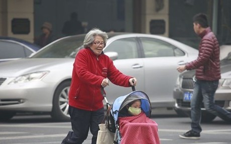 奶奶手推戴著防塵口罩的小孩